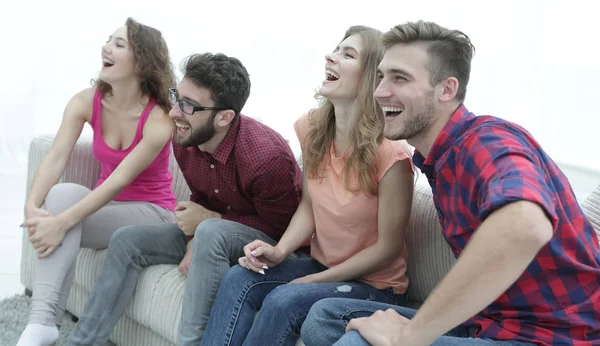 Groupe de jeunes gens souriants assis sur le canapé — Photo