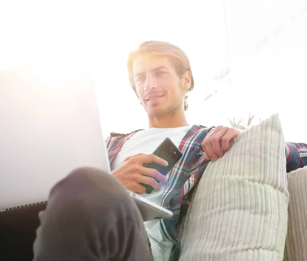 Erfolgreicher Kerl sitzt auf Sofa im Wohnzimmer — Stockfoto