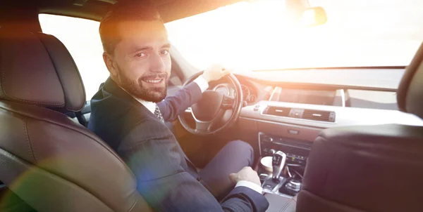 Επιτυχημένος άνθρωπος κάθεται πίσω από το τιμόνι ενός αναγνωρισμένου αυτοκινήτου — Φωτογραφία Αρχείου