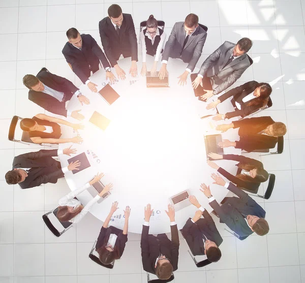 Group of business people sitting at the round table, and putting his palms on the table — Stock Photo, Image