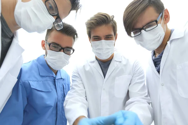 Primer plano. un equipo de médicos con máscaras protectoras . —  Fotos de Stock