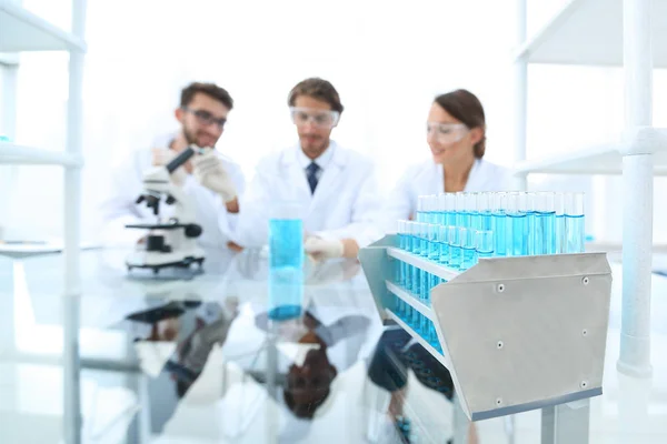 Imagen de fondo de los científicos que estudian líquido azul en un frasco — Foto de Stock