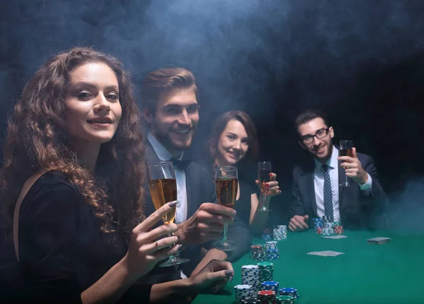カジノでのゲームのテーブルに座っている友人のグループ — ストック写真