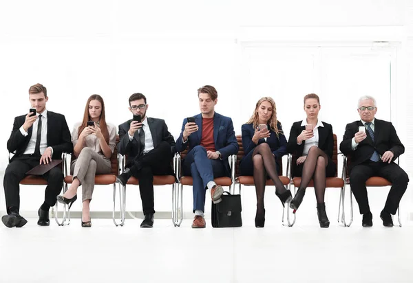 Groep van mensen uit het bedrijfsleven met smartphones zitten in de rechtszaal — Stockfoto