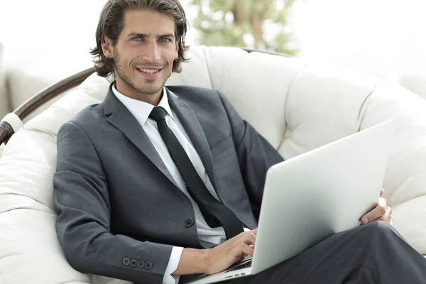 Επιχειρηματίας με ένα φορητό υπολογιστή που κάθεται σε ένα μοντέρνο άνετο chai — Φωτογραφία Αρχείου