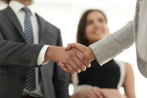 Businesspeople  shaking hands against room with large window loo — Stock Photo, Image