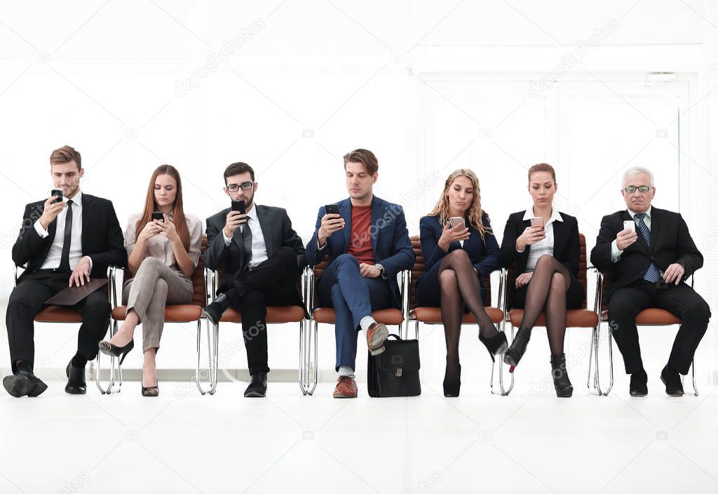 group of business people with smartphones sitting in the courtroom