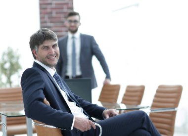 Bir boş toplantı odasında oturan işadamı