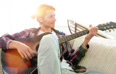 oturma odasında kanepede oturup gitar ile Modern adam.
