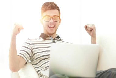 mutlu adam kanepede oturan dizüstü bilgisayar ile