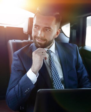 Bir arabanın arka koltuğunda oturan başarılı adam