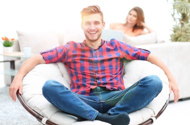 arka plan bulanık bir büyük yuvarlak sandalyede oturan modern genç adam