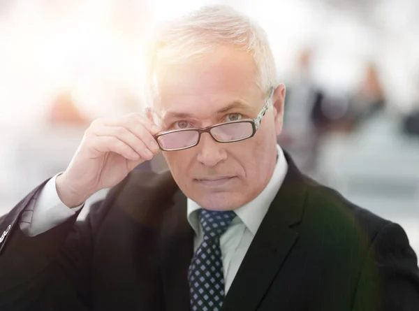 Close-up de um empresário sênior ajustando seus óculos — Fotografia de Stock