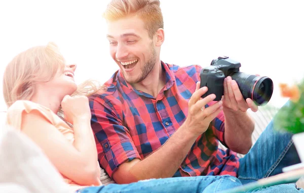 Современная молодая пара смеется и обсуждает фотографии на камеру — стоковое фото