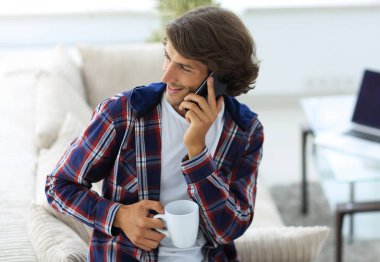 güzel bir fincan adamla bir dizüstü bilgisayar önünde oturur.