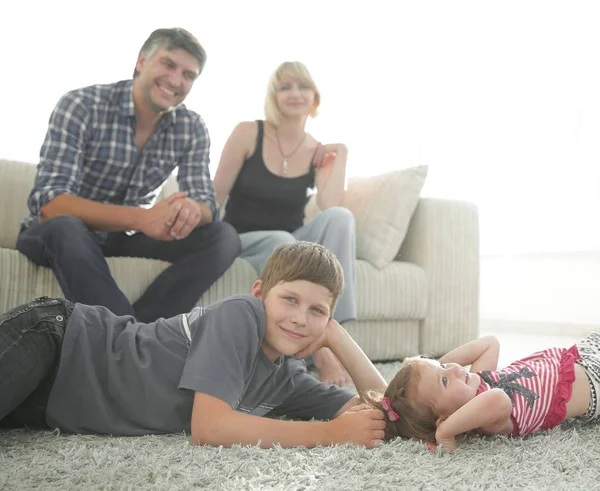 Ritratto di bambini mentre i genitori si siedono sul divano in salotto — Foto Stock