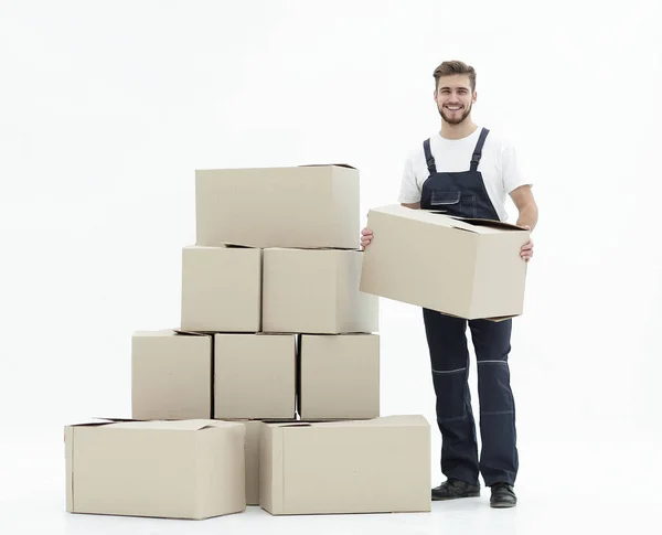 Junger Mann trägt eine Schachtel zum Kartonstapel. — Stockfoto