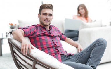 büyük sandalyede oturan genç adam