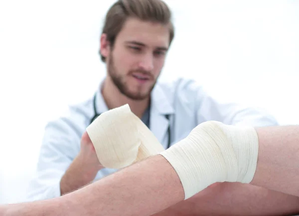 Γιατρός bandaging ένα τραύμα στο πόδι του ασθενούς — Φωτογραφία Αρχείου