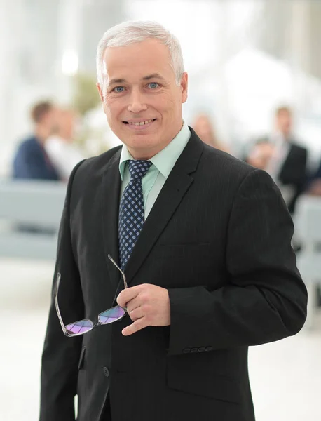 Primer plano de un empresario sénior serio con gafas en la mano . — Foto de Stock