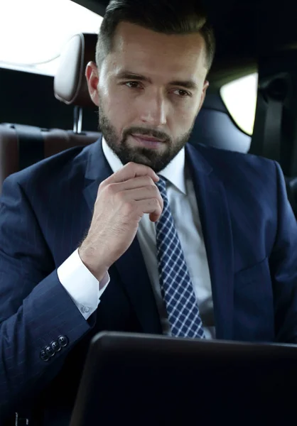 快適な車に座ってノート パソコンを持つビジネスマン — ストック写真