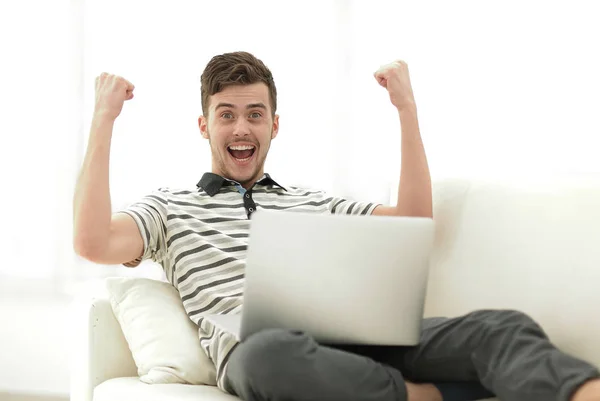 Homem feliz com laptop sentado no sofá — Fotografia de Stock