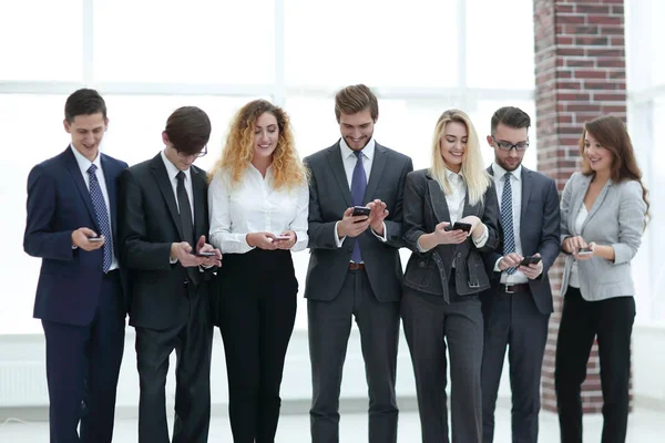 Üzleti csapat látszó-hoz smartphone-ban Hivatal — Stock Fotó