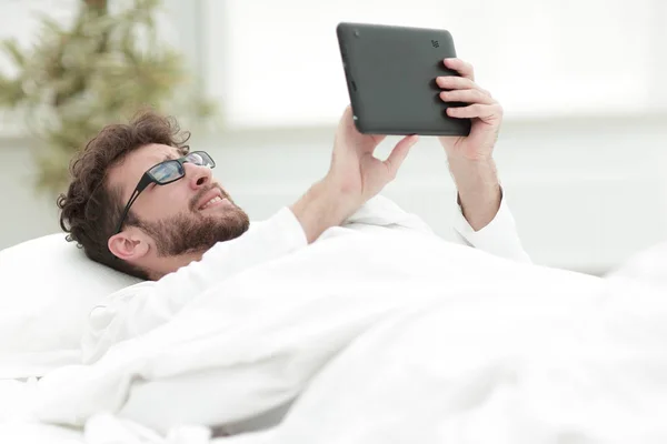 Closeup.Sleepy člověk při pohledu na obrazovku digitální tabletu. — Stock fotografie