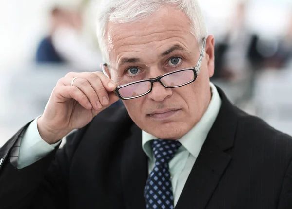 Крупним планом старший бізнесмен коригує окуляри — стокове фото