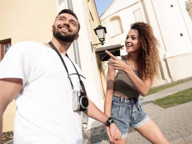 Bir çift şehrin sokaklarında yürüyor ve eğleniyor.