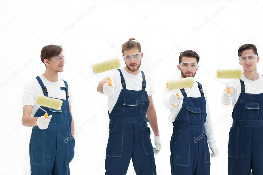 team of builders with paint rollers