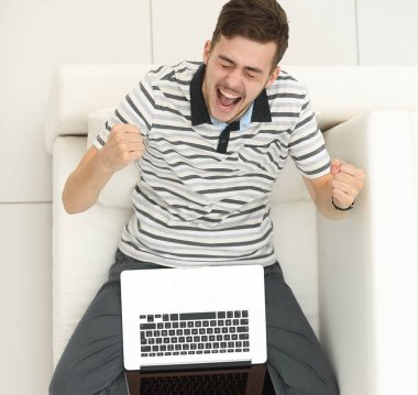 En baştan görüntüleyin. kanepede oturan dizüstü bilgisayar ile Skordan genç adam