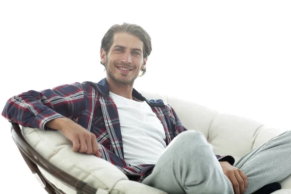 Primer plano de un chico sonriente acariciando a su perro mientras está sentado en un sillón grande . —  Fotos de Stock