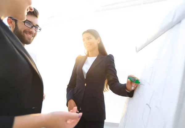 Business woman pointing with a marker on the flipchart — Stock Photo, Image