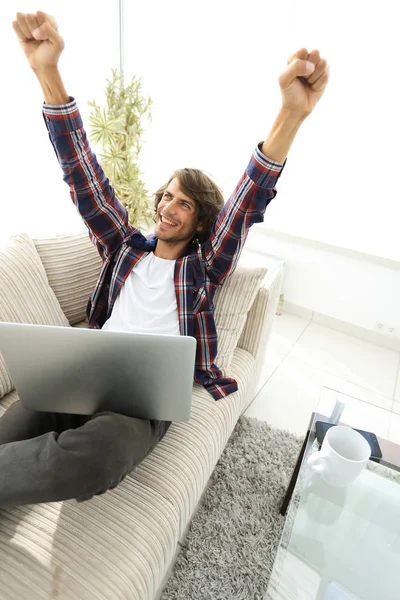 Chico muy feliz trabajando con el ordenador portátil en casa . — Foto de Stock