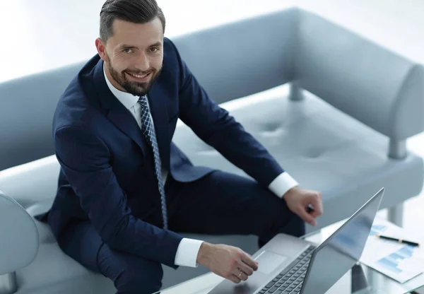 Hombre de negocios trabajando en un ordenador portátil con gráficos financieros —  Fotos de Stock