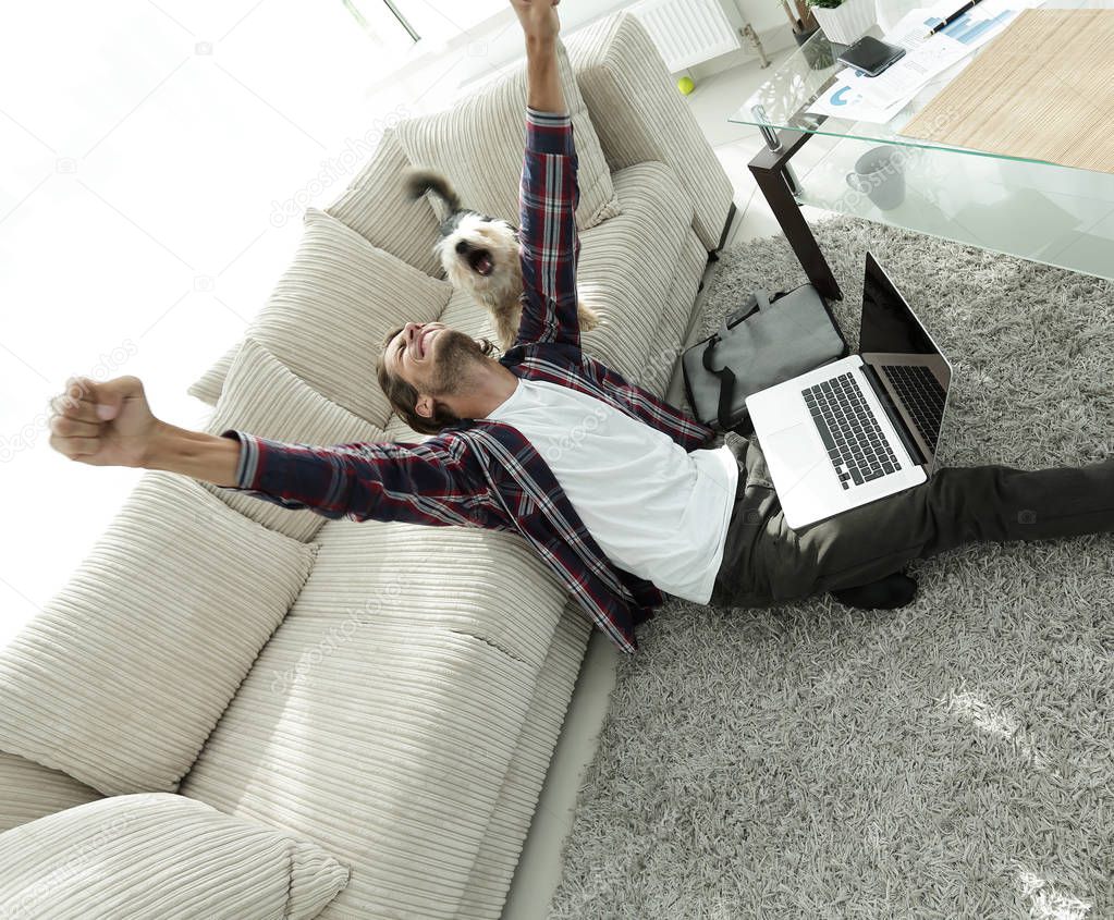 happy guy with his dog sitting in a spacious living room