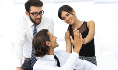 Birbirimizi bir beşlik veren genç iş arkadaşları