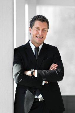 office penceresinde yakınındaki ayakta ciddi iş adamı.