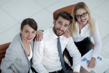 masada oturan ve kameraya bakarak başarılı iş takım.