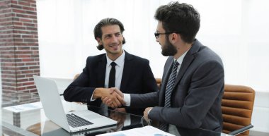 bir masanın arkasında oturan karşılıklı iş adamı.