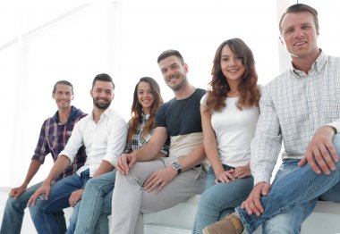 bekleme odasında sandalyelere oturan genç yaratıcı insanlar