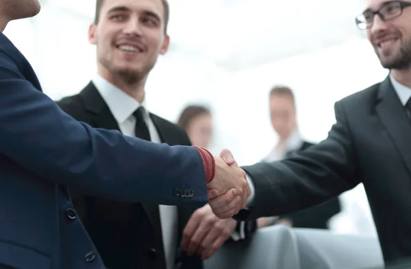 Partners concluding deal and shaking hands in the presence of team members — Stock Photo, Image