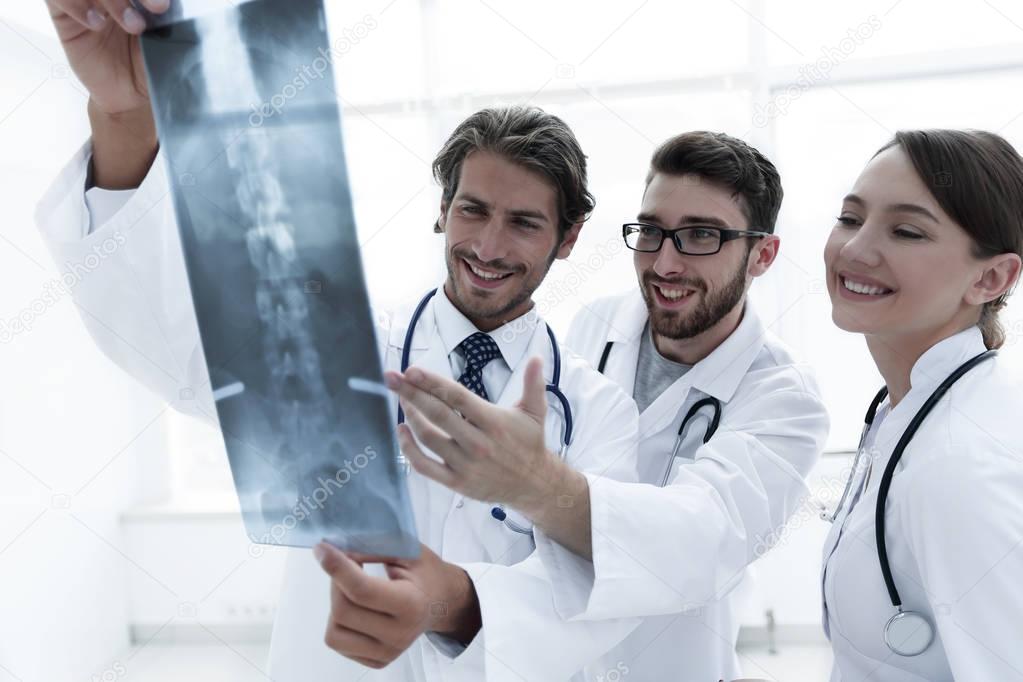 Three confident doctors examine an x-ray