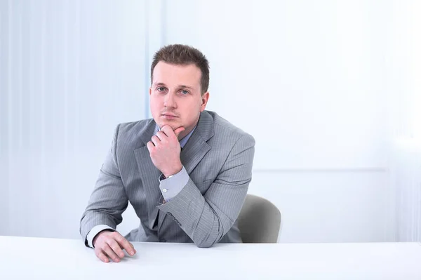 Успешный бизнесмен, сидящий за столом — стоковое фото