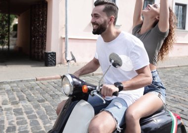 mutlu genç bir çift bir scooter üzerinde eğleniyor