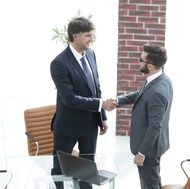 İki işadamı ofiste el sıkışıyor.