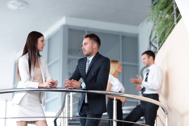 İş adamları molası verdikten ve ofis binası terasta konuşuyor.
