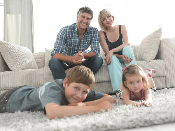 Retrato de família feliz sentados juntos na sala de estar — Fotografia de Stock