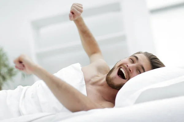 Glücklicher Mann wacht in einem komfortablen Zimmer auf — Stockfoto
